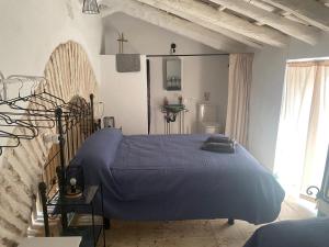 a bedroom with a bed with a blue comforter at Moreria Suites in Constantina