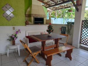 a dining room with a table and a bench at Dell Osky Pousada in Florianópolis