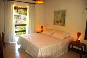 sypialnia z łóżkiem i dużym oknem w obiekcie Pousada Coisa e Tao w mieście Arraial d'Ajuda