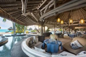 a restaurant at the beach with tables and chairs at Conrad Bora Bora Nui in Bora Bora