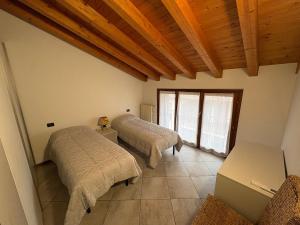 a bedroom with two beds and a wooden ceiling at Hub 2A in Calcio