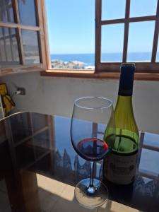 a glass of wine next to a bottle of wine at Casa de playa con espectacular vista in Islote Ramadas