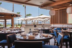 a restaurant with tables and chairs and large windows at Hotel del Coronado, Curio Collection by Hilton in San Diego