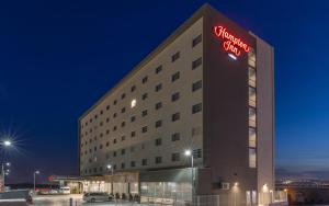 a hotel building with a sign on it at night at Hampton Inn By Hilton Tijuana in Tijuana