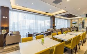 a restaurant with white tables and yellow chairs at Hampton Inn By Hilton Tijuana in Tijuana