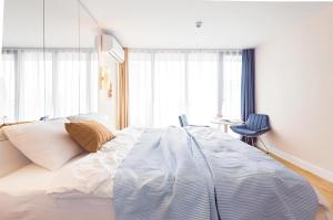 a bedroom with a large white bed and a chair at Panorama Black Sea View Sunset Hotel in Batumi