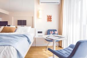 a bedroom with a bed and a table and a chair at Panorama Black Sea View Sunset Hotel in Batumi +41 photos