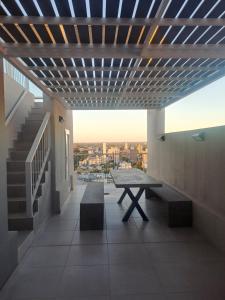 a balcony with a table and bench on a building at Departamento equipado en el macrocentro santa fe in Santa Fe