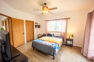 a bedroom with a bed and a ceiling fan at Hilo Vacation Rental in Hilo