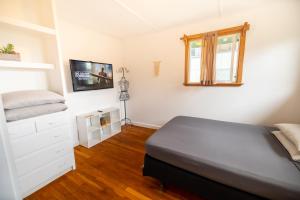 a bedroom with a bed and a tv on the wall at Hilo Vacation Rental in Hilo