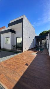 a large building with a wooden deck in front of it at Casa Condeixa in Cabo Frio