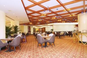a restaurant with tables and chairs in a room at Al HAYAT PALACE HOTEL in Sharjah