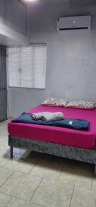 a bed in a room with a pink mattress at Pousada Familiar 03 in Rio do Sul