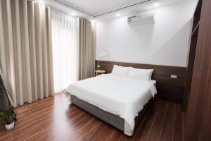 a bedroom with a white bed and a window at Mom's home in Ninh Binh