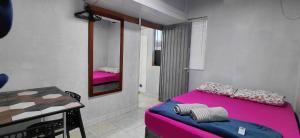 a room with a bed and a table and a mirror at Pousada Familiar 03 in Rio do Sul