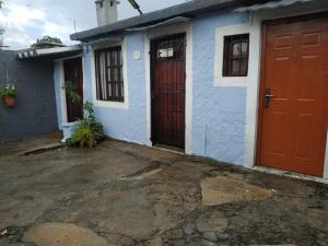 a blue and white house with red doors at Alojamiento Victoria in Montevideo