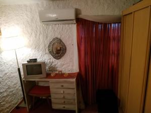 a bedroom with a desk with a computer and a bed at Alojamiento Victoria in Montevideo