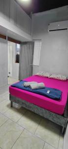 a bed in a room with a pink mattress at Pousada Familiar 03 in Rio do Sul