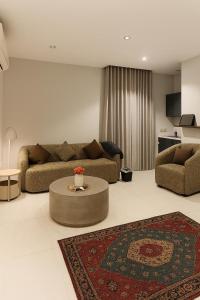 a living room with two couches and a table at Sunshine Flat in Al Khobar