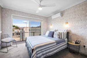 a bedroom with a bed and a balcony at Ocean Shores 1 in South West Rocks +9 photos