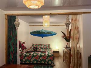 a bedroom with a bed and a painting on the wall at Hiva's Place climatisé terrasse vue sur mer -Huahine in HUH