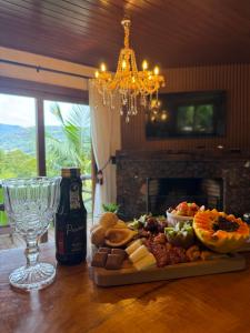 a plate of food on a table with a wine glass at Cabana Valle Pietra in Nova Petrópolis