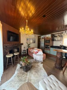 a living room with a couch and a chandelier at Cabana Valle Pietra in Nova Petrópolis +12 photos