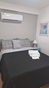 a bedroom with a large bed with black sheets and pillows at Vista Espetacular e Estúdio Novo in Niterói +29 photos