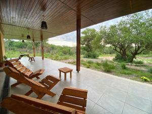 a porch with benches and tables and a view of a field at Estación Tachyón Timalu , ETe-Nea in San Esteban +14 photos