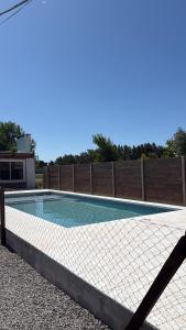 a swimming pool in a backyard with a fence at Salesta San Pedro in San Pedro