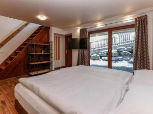 a bedroom with a large white bed and a window at Golden Hirsch in Rauris