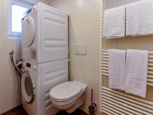 a white bathroom with a toilet and a window at Golden Hirsch in Rauris +29 photos