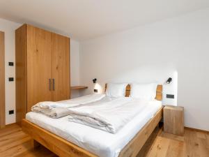a bedroom with a large bed with white sheets at Haus Tauernblick Top 4 in Jochberg