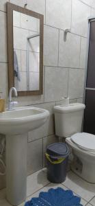 a bathroom with a sink and a toilet and a mirror at Pousada familiar 02 in Rio do Sul