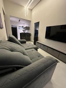 a room with three beds and a flat screen tv at Casa Condeixa in Cabo Frio