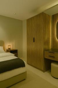 a bedroom with a bed and a wooden cabinet at Sunshine Flat in Al Khobar