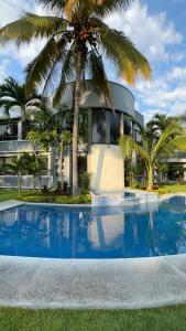 a house with a palm tree in front of a swimming pool at Residencia privada de 10 habitaciones para 20 personas in Chiconcuac