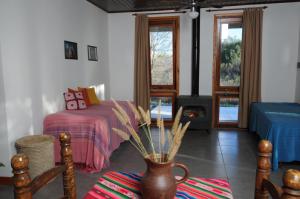 a bedroom with a bed and a vase with flowers in it at Estación Tachyón Timalu , ETe-Nea in San Esteban