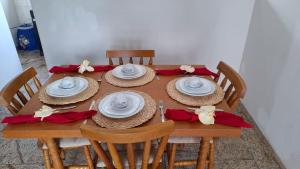 a wooden table with hats and napkins and red bows at SUÍTE Solar do Carmo in Mariana +28 photos