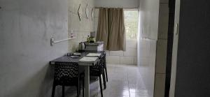 a kitchen with a table and chairs and a window at Pousada familiar 02 in Rio do Sul