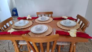 a wooden table with hats and red napkins on it at Solar Banheiro Privativo in Mariana