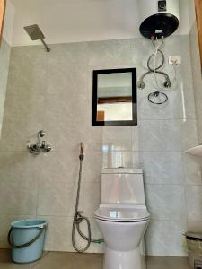 a bathroom with a toilet and a picture on the wall at Sompal Service Apartment in Paro +16 photos