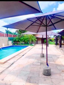 a blue umbrella sitting next to a swimming pool at Sitio Resenha in Caucaia