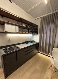 a kitchen with a stove and a counter top at Studios Botânico in Curitiba