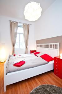 um quarto com uma grande cama branca com almofadas vermelhas em Budget Apartment em Praga