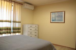 a bedroom with a bed and a dresser next to a window at Willunga Farm Retreat in Willunga