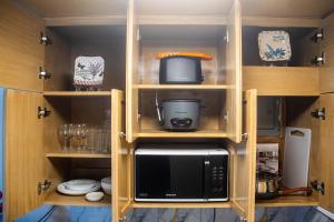 a kitchen with wooden cabinets with a microwave at CLBC Residences 1A in Ibaba
