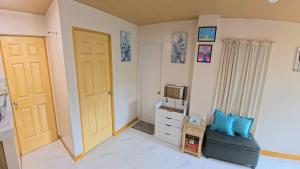 a room with a door and a couch and a tv at CLBC Residences 1A in Ibaba