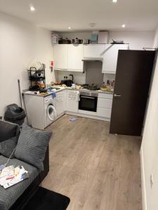 a kitchen with white cabinets and a black refrigerator at Holiday Haven in Potters Bar