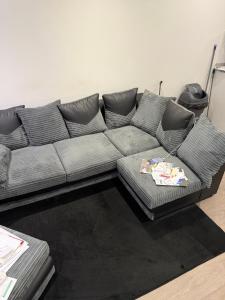 a gray couch in a living room with a table at Holiday Haven in Potters Bar